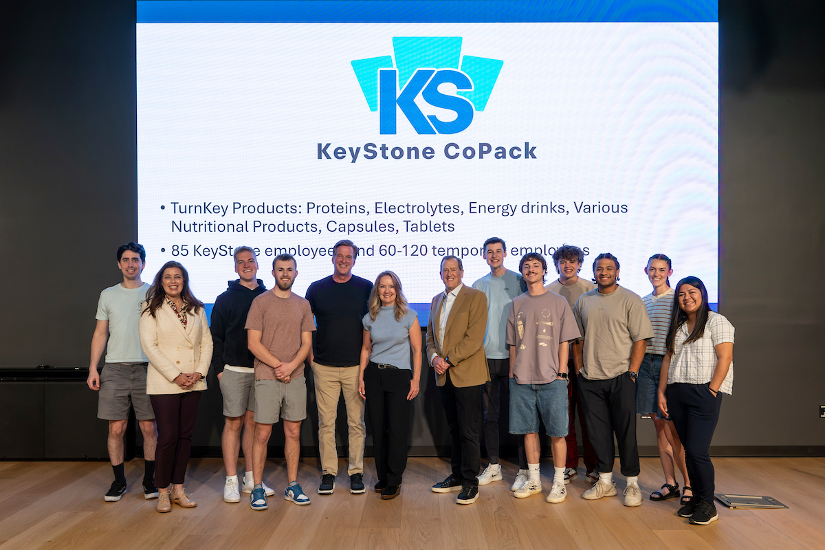  Shannan Busby poses in a group photo with faculty, staff, and students on stage at Vallejo Auditorium during the Reed and Christine Halladay Executive Lecture Series at Utah Valley University.