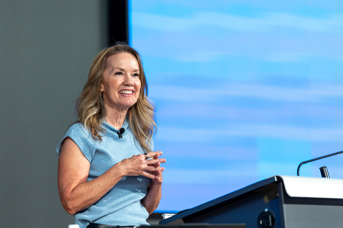 Shannan Busby stands at a podium smiling during her lecture at the Reed and Christine Halladay Executive Lecture Series, held in Vallejo Auditorium. 