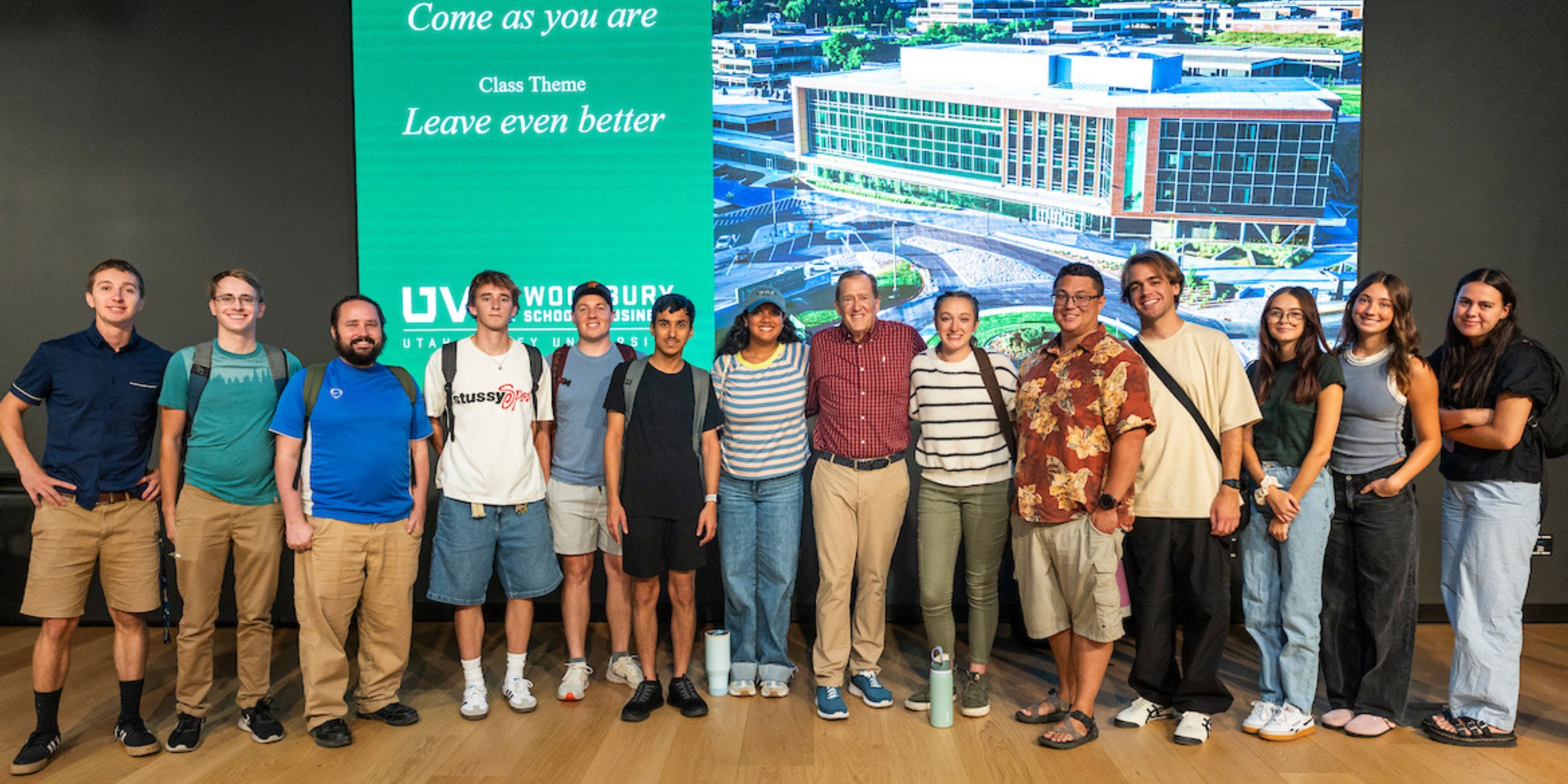 Tom MacDonald stands with UVU business students after the Fall 2025 Halladay Lecture Series session.