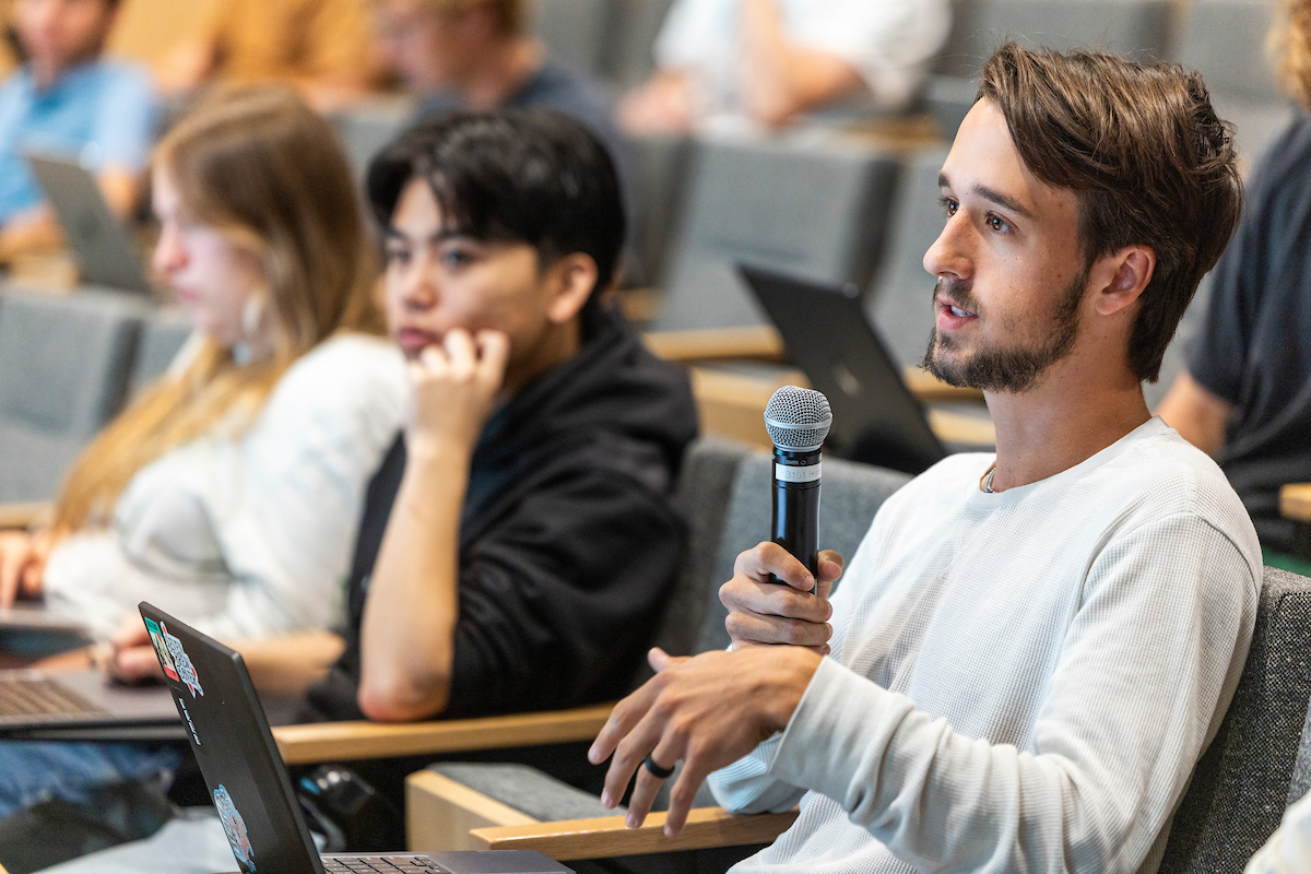 A student asks a question with microphone in hand during Tom MacDonald’s Halladay Lecture.