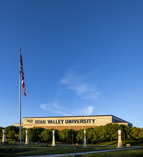 Utah Valley University signage on building with an American flag in front