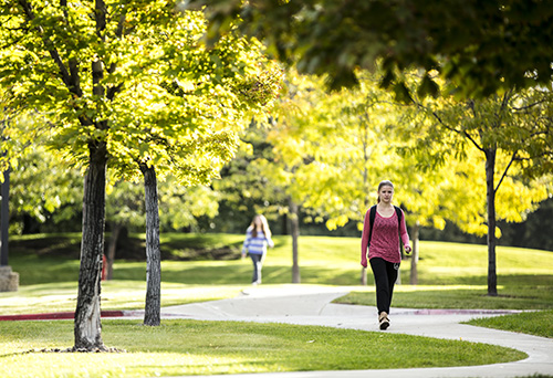 Two students walking on a concrete path