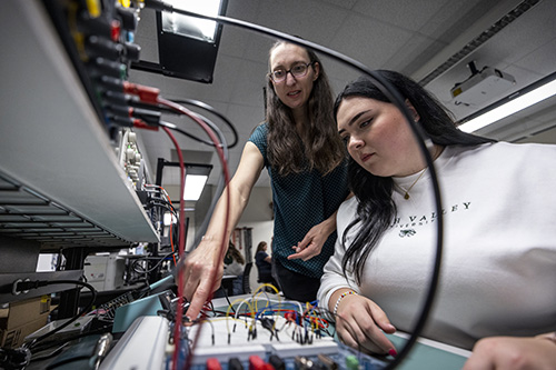 Two students use a breadboard.