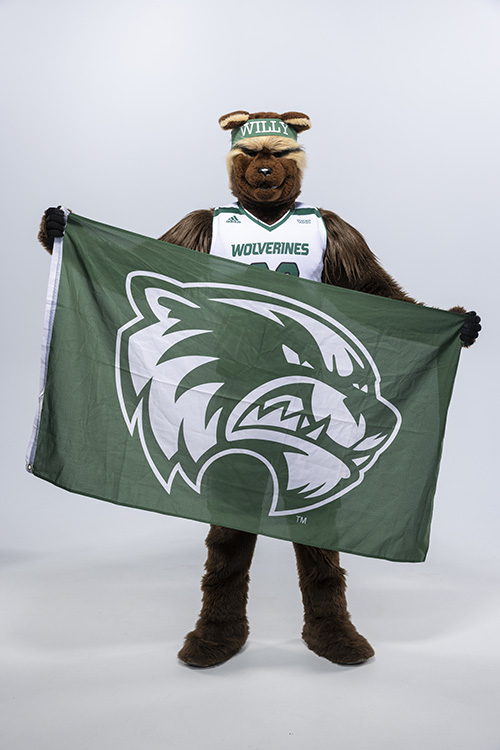Willy the Wolverine holding the athletic UVU flag