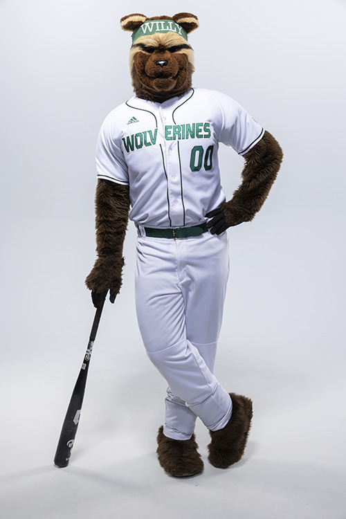 Willy the Wolverine wearing a white baseball uniform and holding a baseball bat