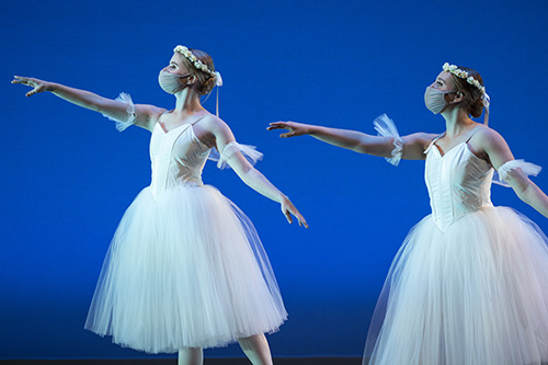 Two ballet dancers wear masks.