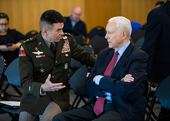 General speaking with a suited man.