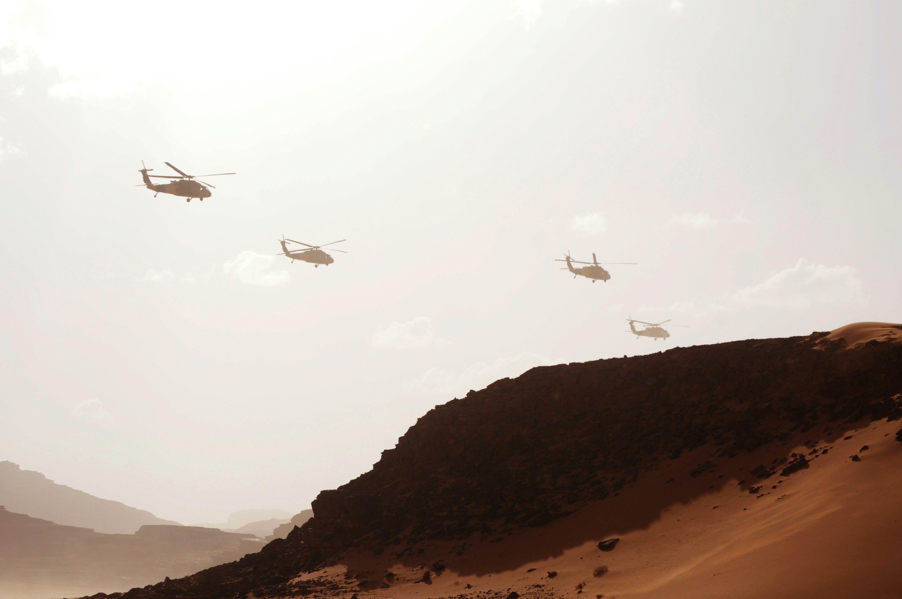 helicopters flying across the sky