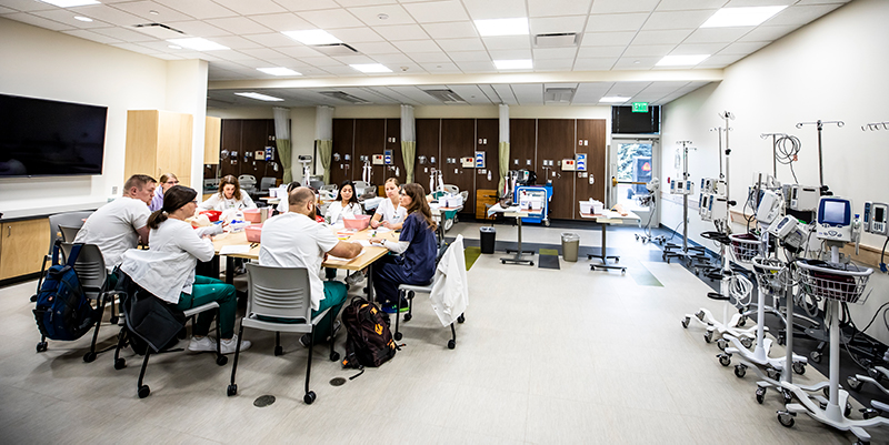 Nursing Students having a debrief around a conference table in the new lab