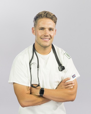 A man in a nurses outfit standing perpendicular to the camera angle