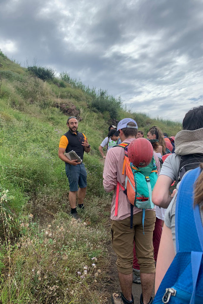 a teacher talking to a group of students in the mountains in Italy