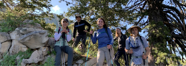 A group of students posing on rocks in the mountains