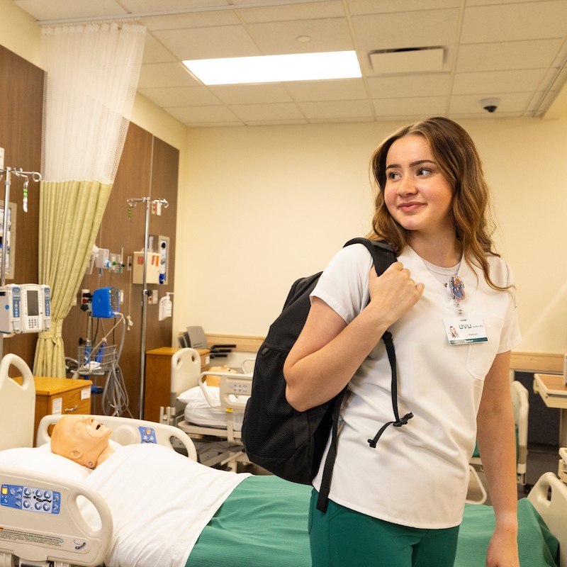 nursing student in front of a hospital bed