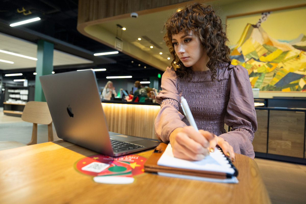 Image of a student using their laptop at a cafe