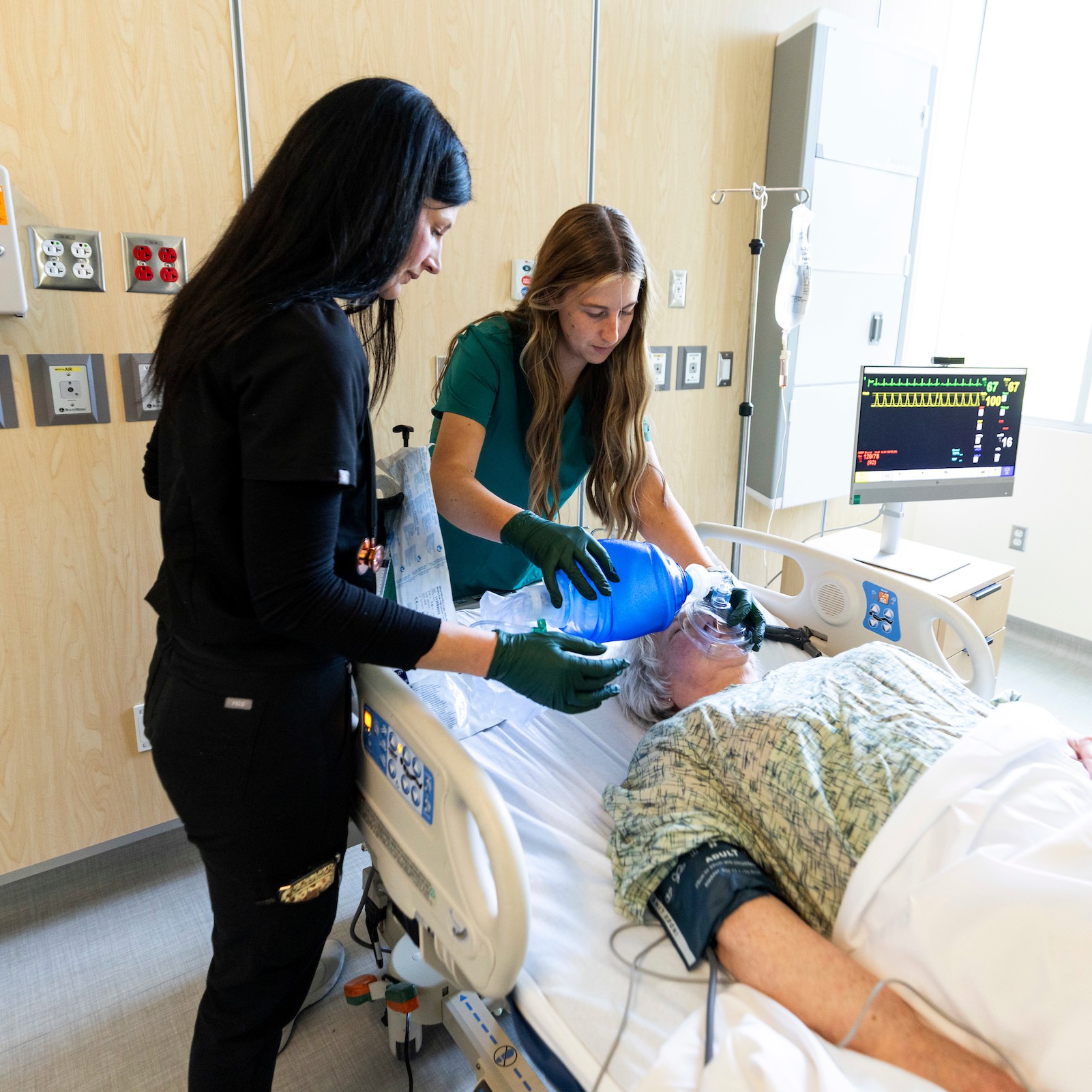 hospital nurse checking on patient in a bed