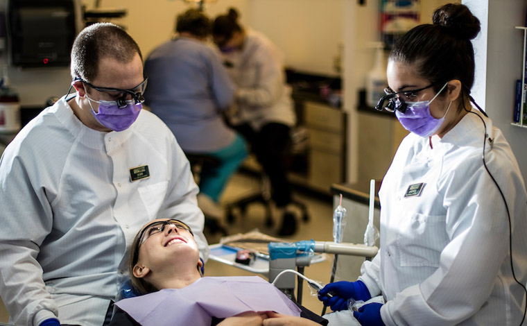 Dentist and dental assistant examining a patient.