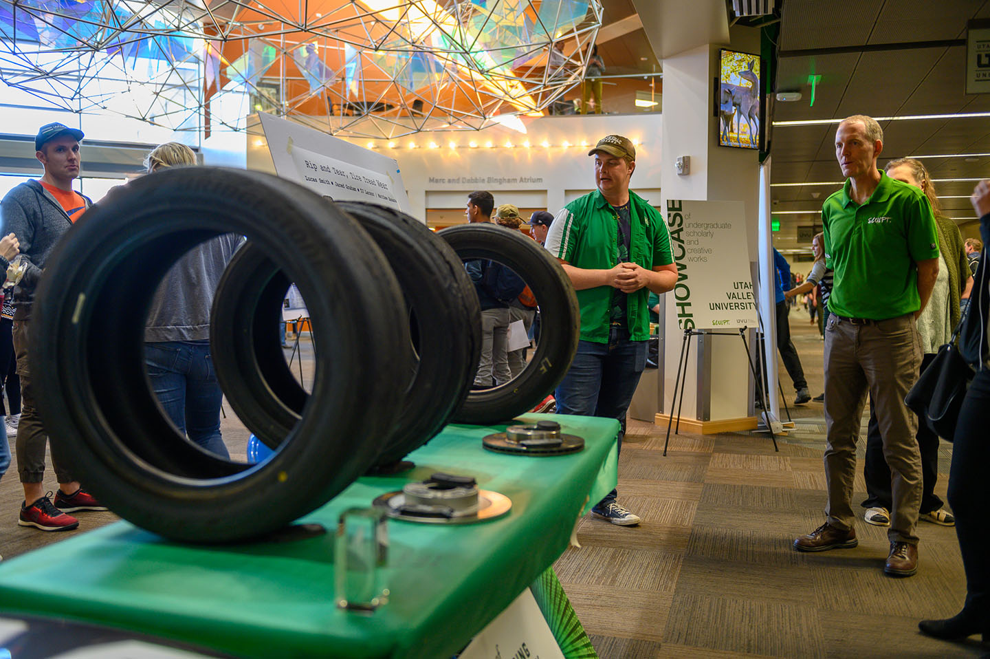 Student presenting to professors and students with car tires on a table