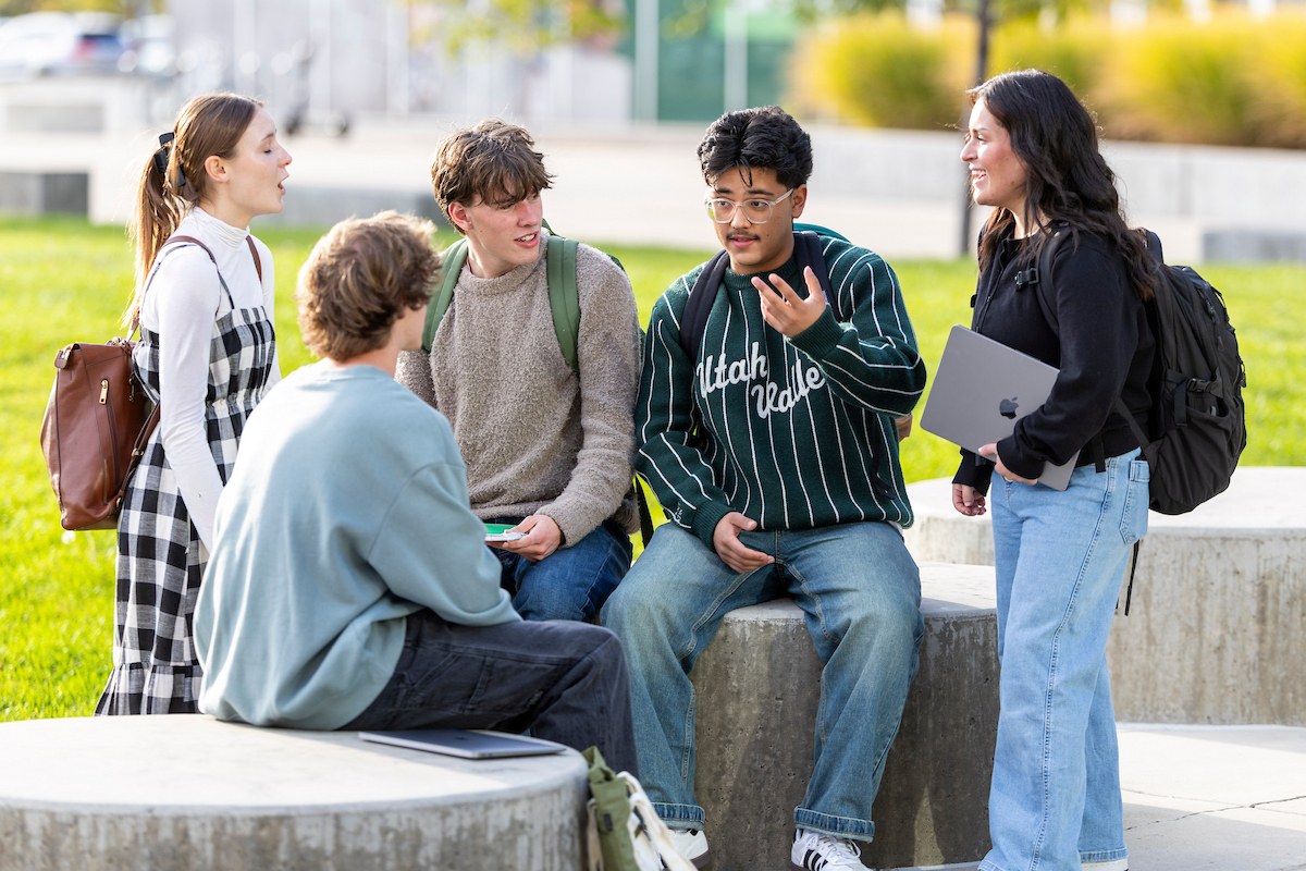 Students gathered outside on campus having a discussion