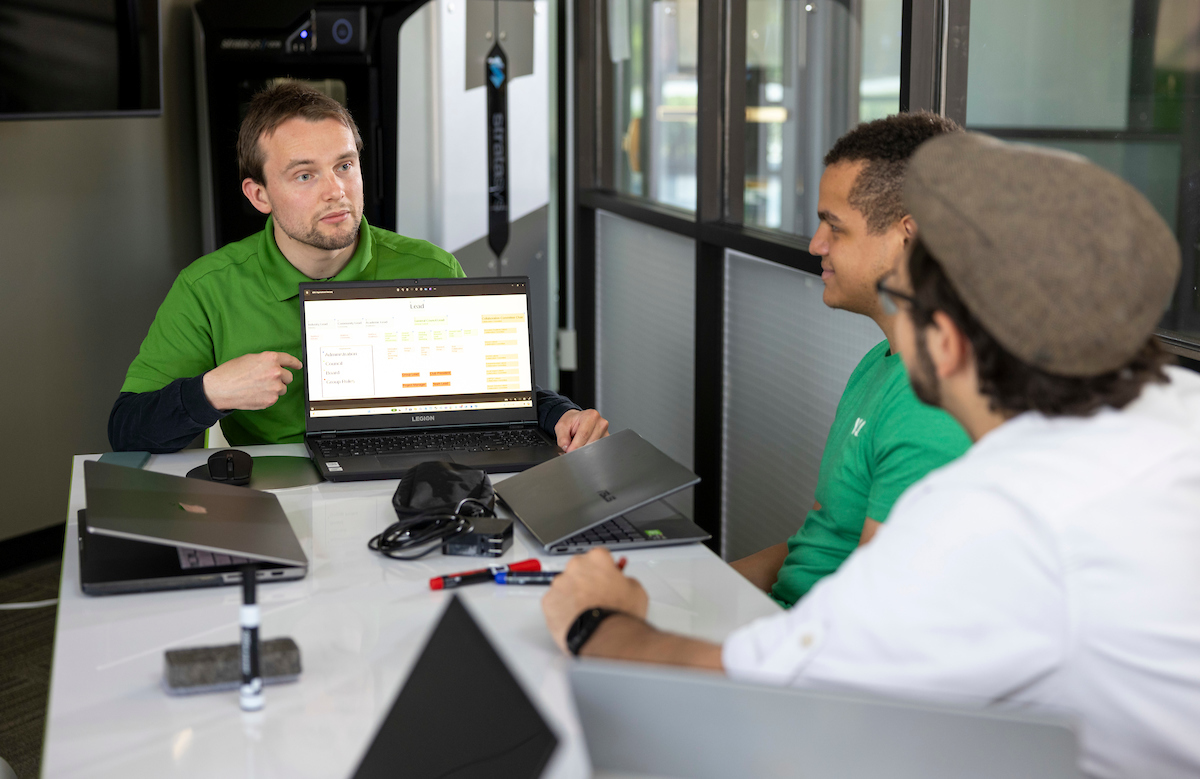 Person running a meeting, people are listening while sat around a table