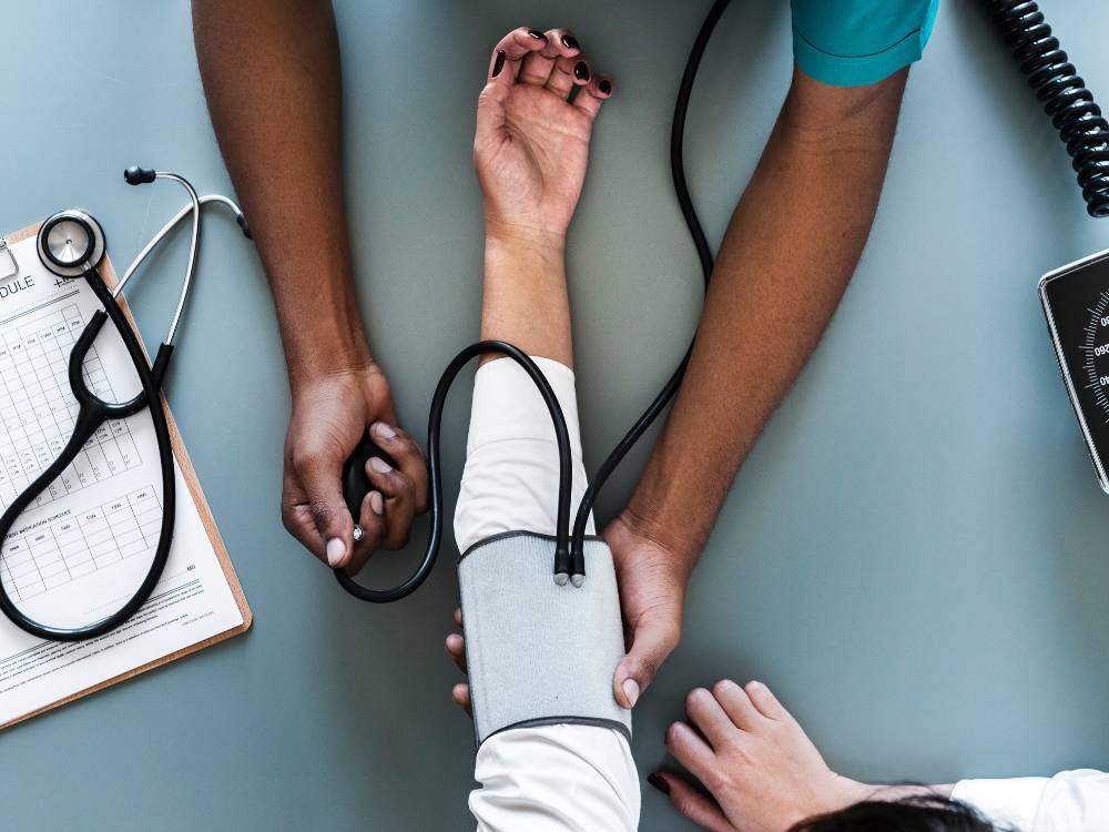 Nurse checking patient's blood pressure'