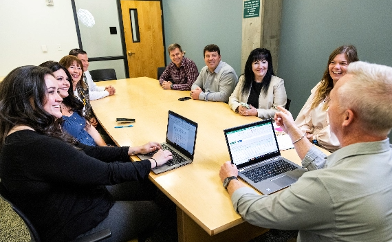 Small group of employees sitting around a conference table.