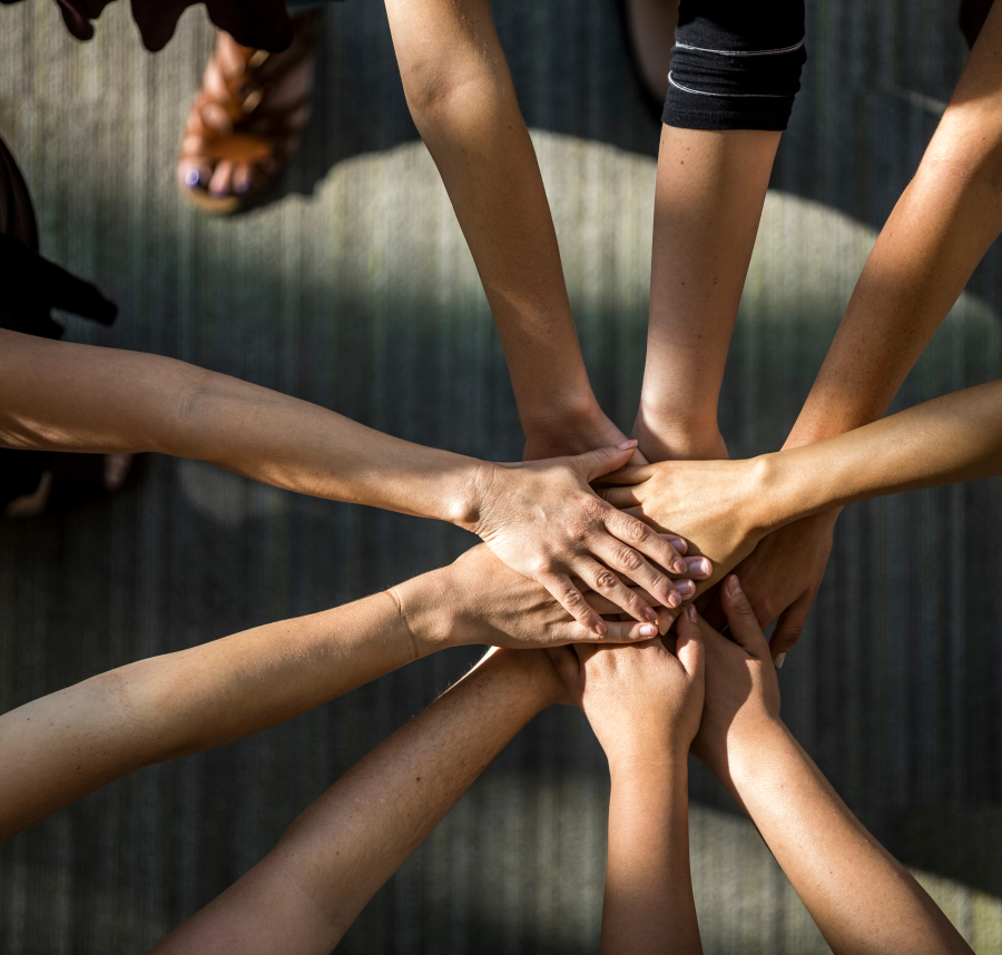 Hands stacked on top of each other in an all-in gesture.