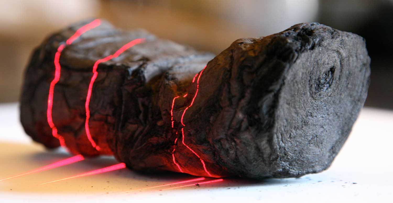 Herculaneum scroll with red laser lines being 3D scanned at Institut de France by Brent Seales and his team.