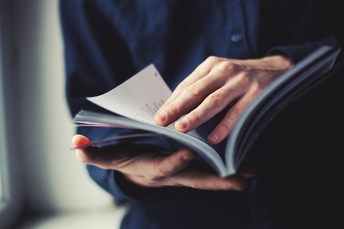 Hands leafing through a notebook