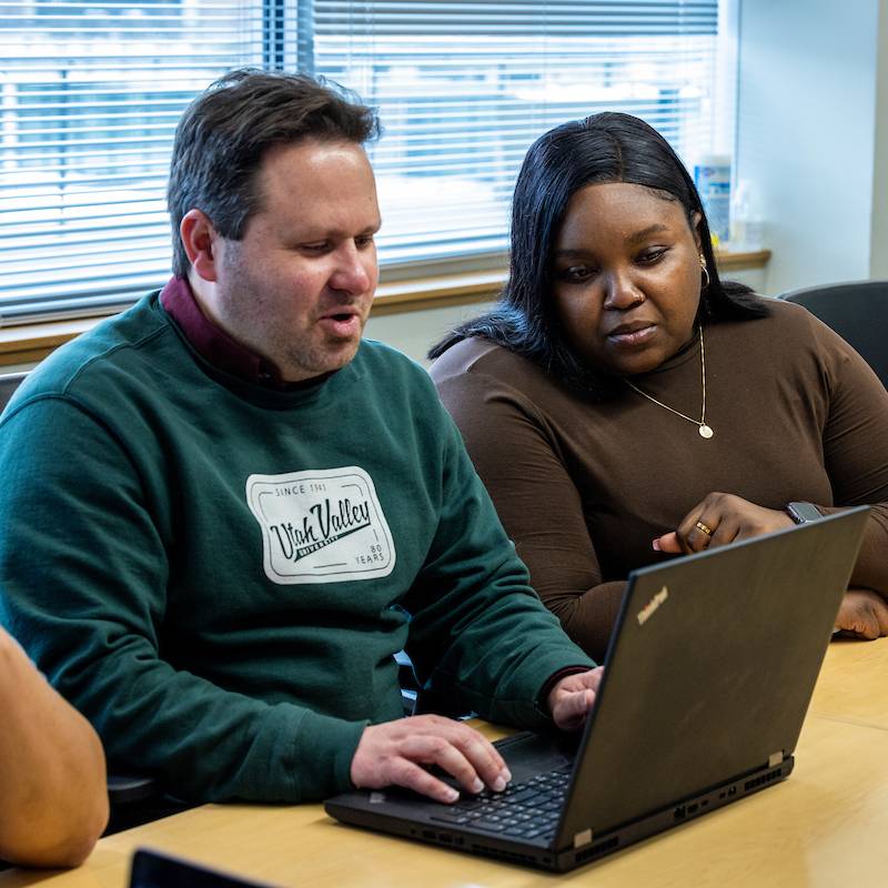 Image of two people looking at a laptop