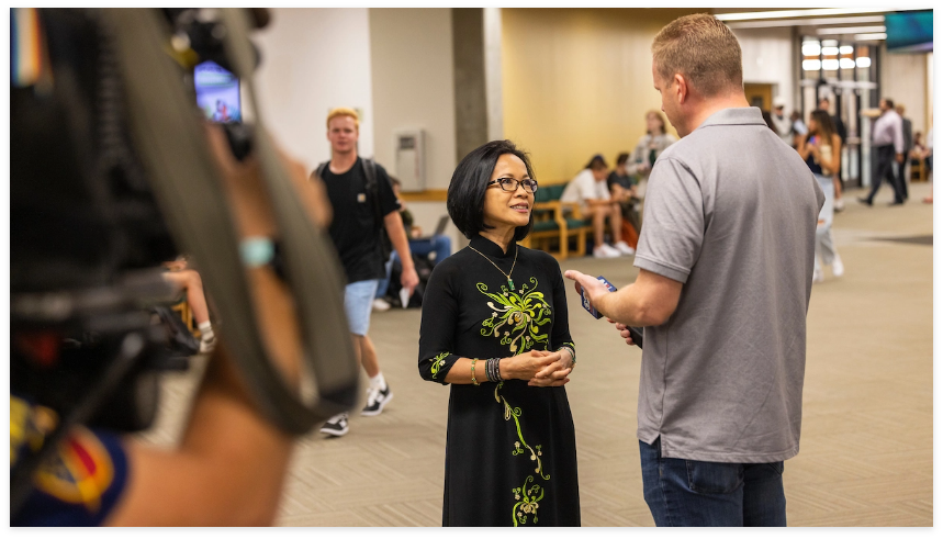 President Tuminez standing in a hallway filming an interview.