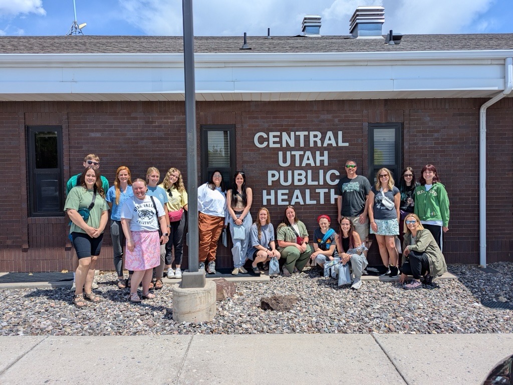 Woman taking vitals of man in hat.