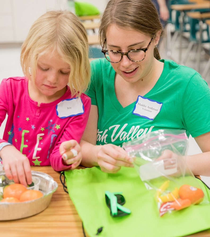 A student teaching a young girl about healthy eating choices