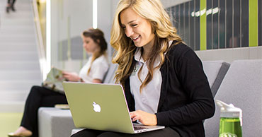Female Student sitting with her Laptop in the classroom building