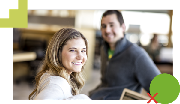 Two students smiling and sitting in the Fulton Library.