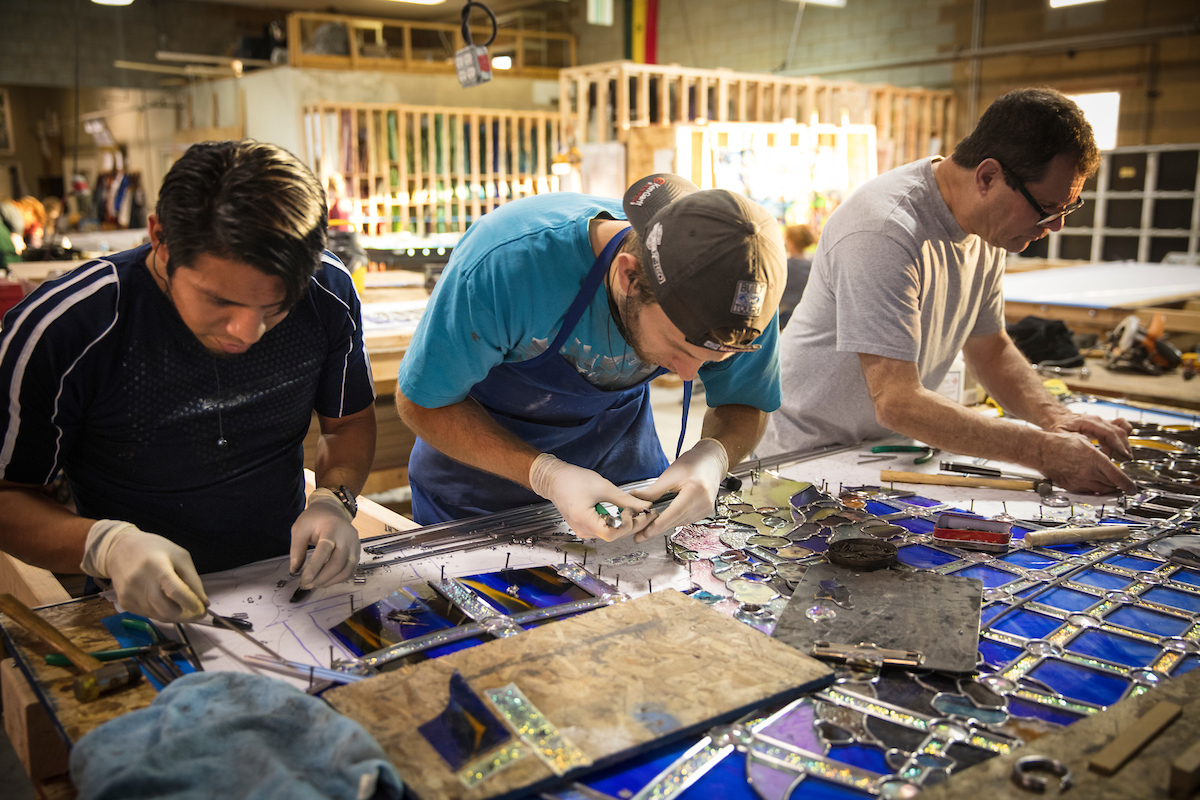 Image of workers cutting out glass panels for the Roots of Knowledge