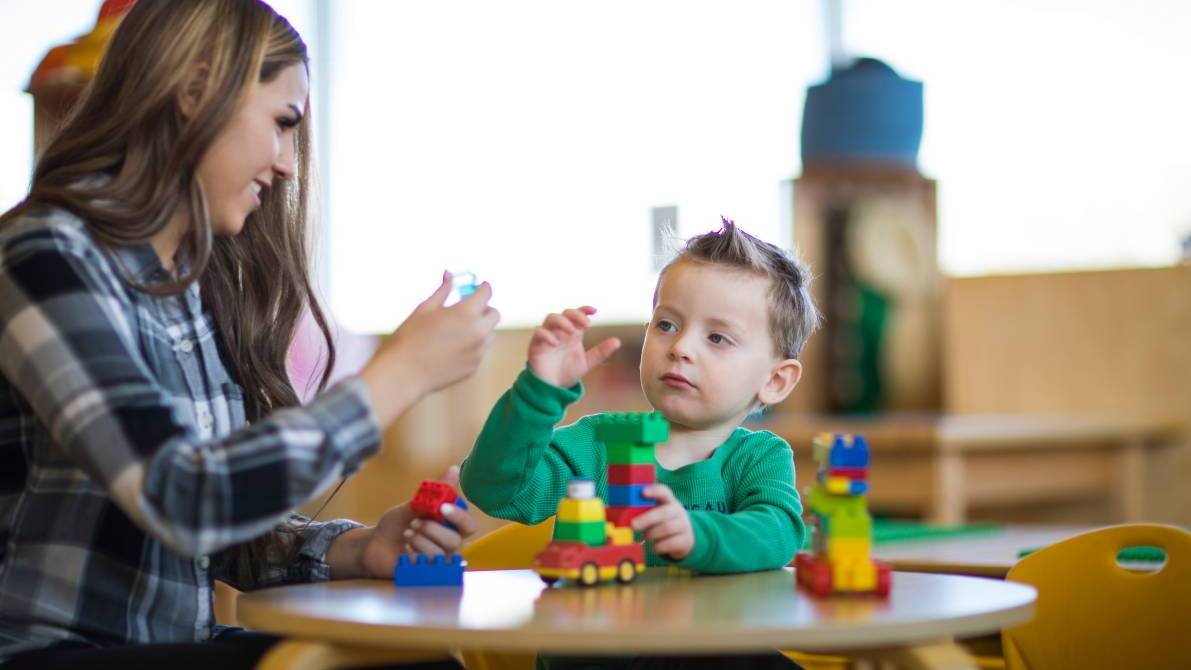 Teacher and child working with educational toys.