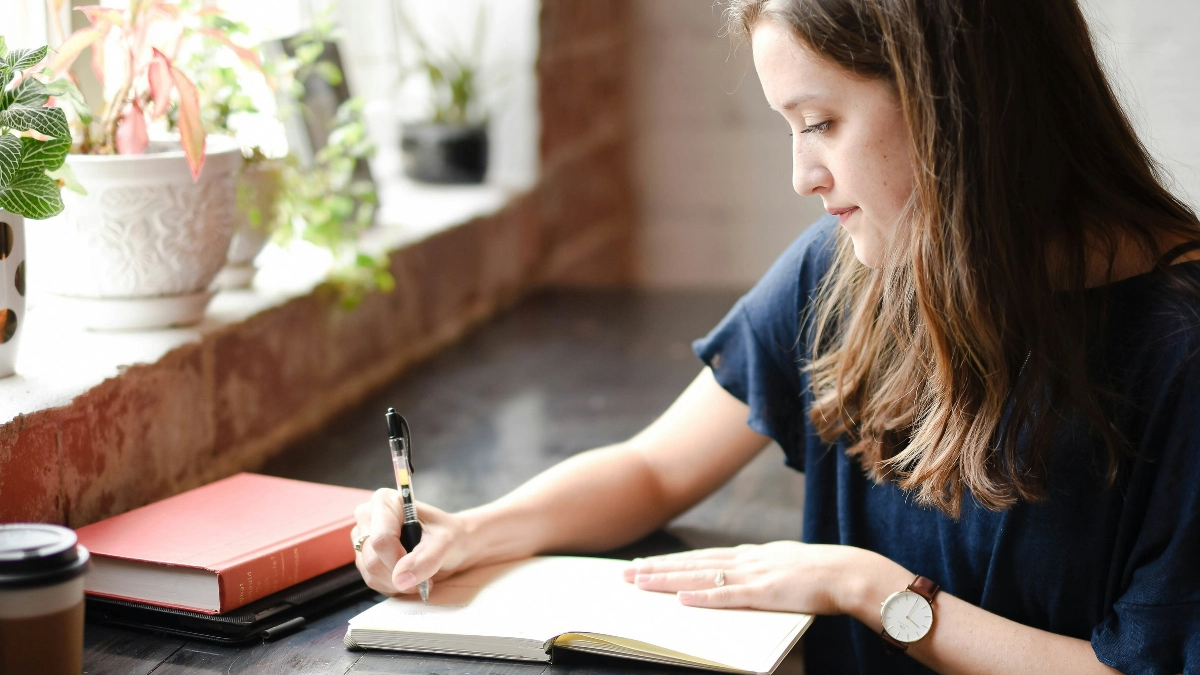 Woman writing in a notebook.