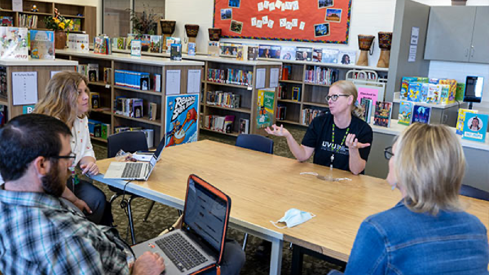 Group of teachers in conversation around a table.