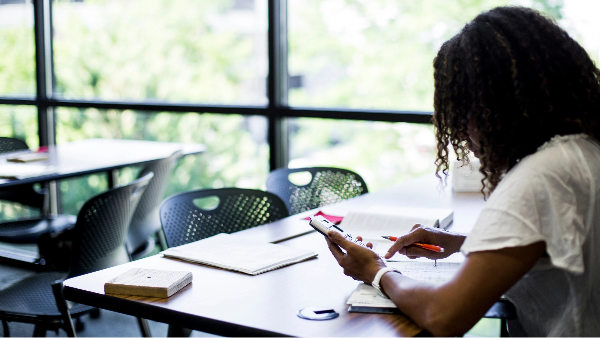 Student sitting at a desk using a calculator