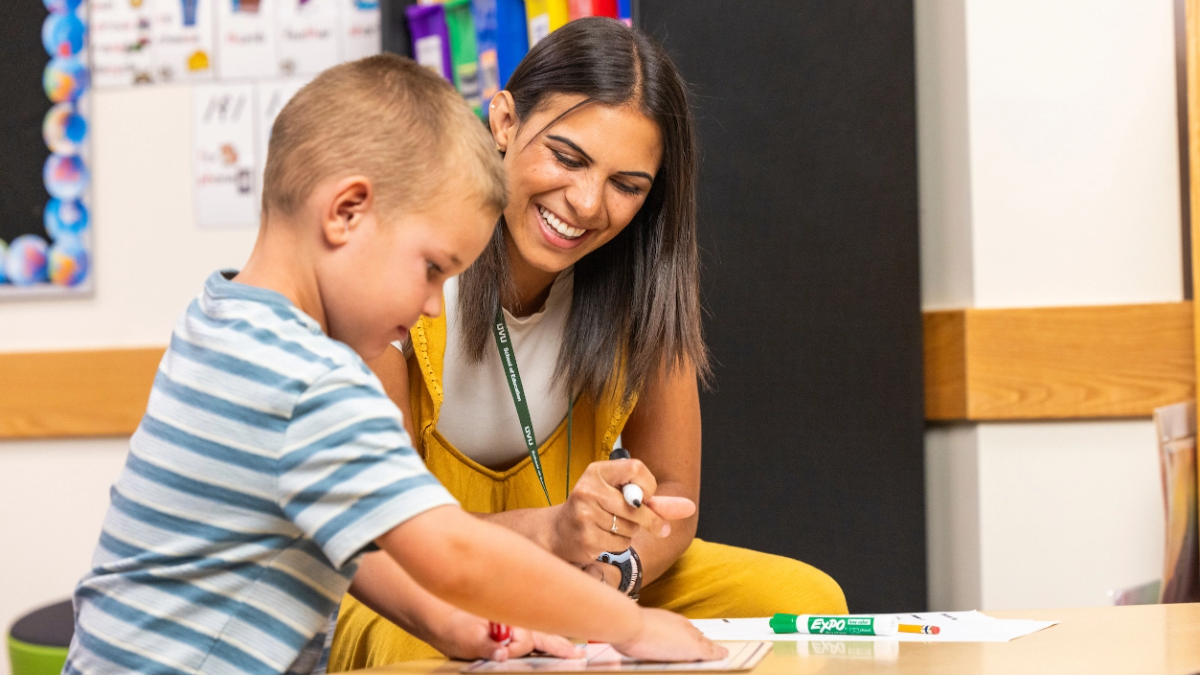 Teacher working with young student.