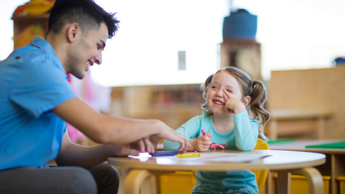 Male teacher working with child.
