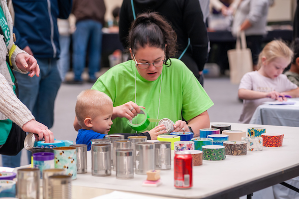Caretaker guiding small child in project