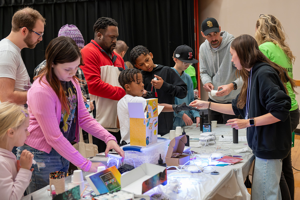 Children and caretakers interact with activities at a table.