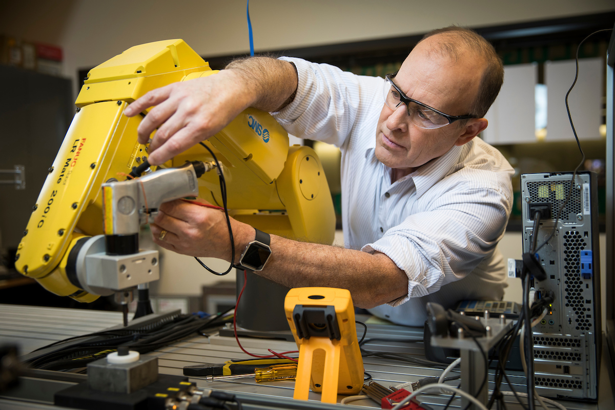 Professor working on machinery