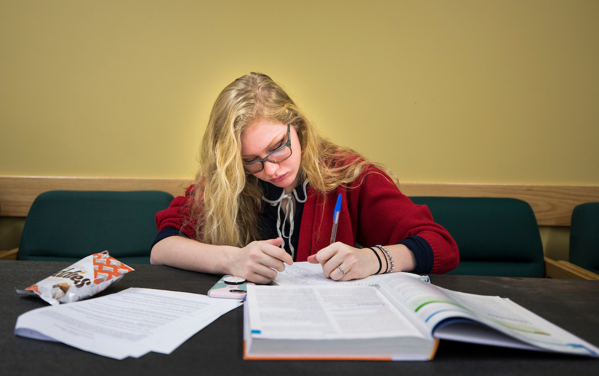 Student reading through a textbook