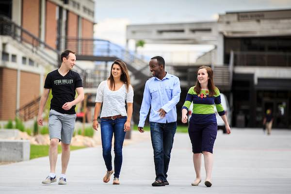 Four students walking outside