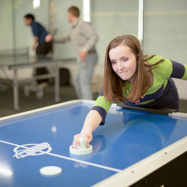 Student playing air hockey at the UVU gaming center