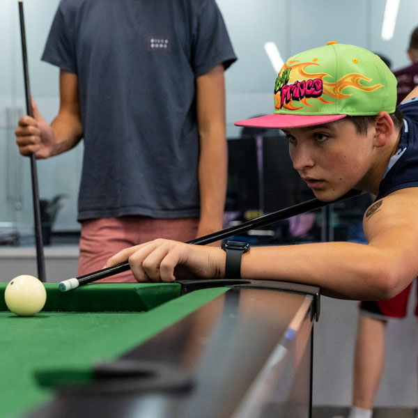 UVU student playing pool at the gaming center