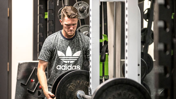 UVU student lifting free weights at SLWC gym