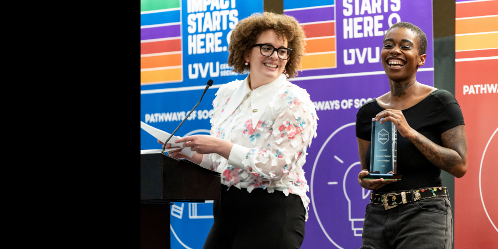 presenter and student smiling on colorful stage